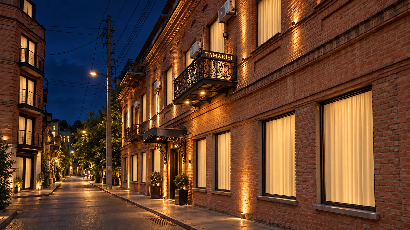 Artistic nighttime visualization of New Tamarisi Hotel with warm exterior lighting and closed curtains